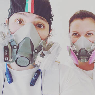 Two Bloom employees wearing respirator masks for safety for spraying paint.