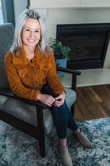 Bloom owner Amy Hayes sitting in a chair smiling at the camera